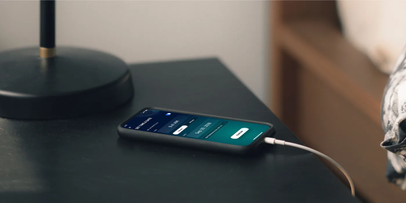The app on a phone by the bed